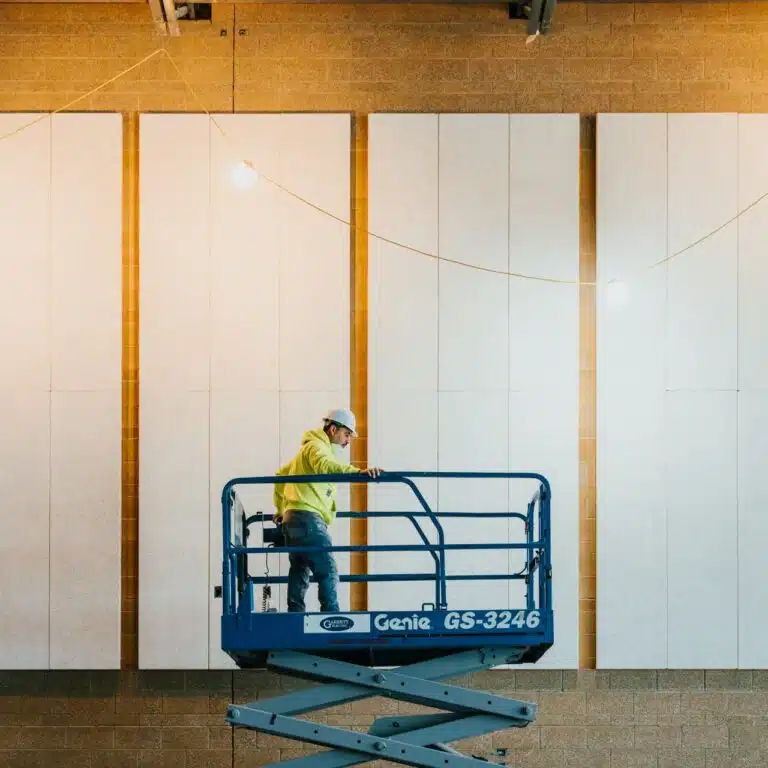 commercial painting contractor at work standing in a crane Paintmaster Services