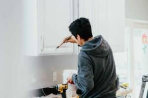 professional painter painting the kitchen cabinets Paintmaster Services