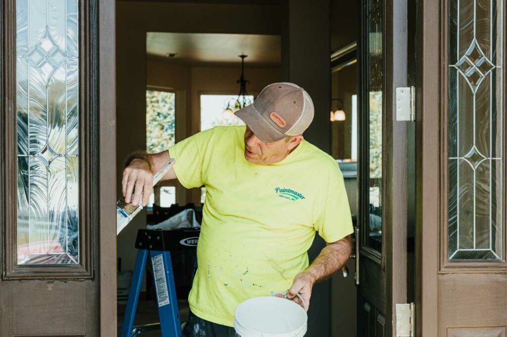 skilled painter painting the door of a house Paintmaster Services