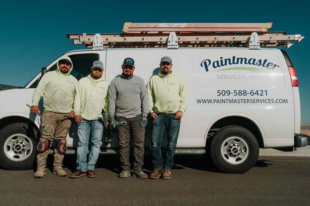 the paintmaster team standing infront of their service van
