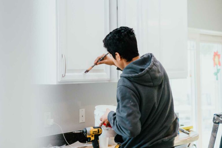 skilled painter from Paintmaster Services painting the kitchen cabinet